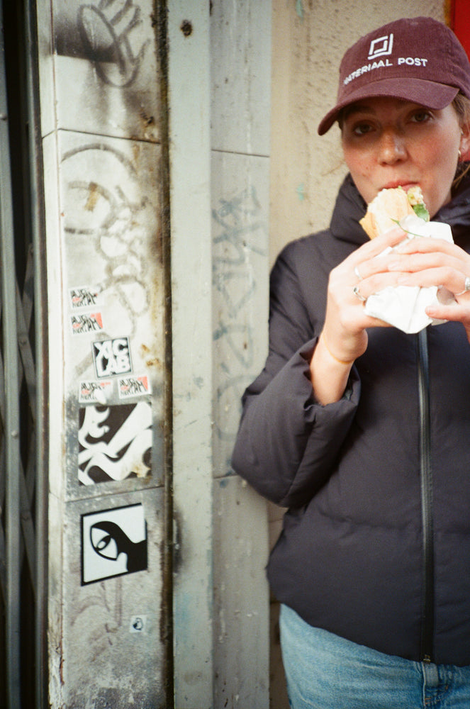 A quiet moment between trips, wearing a Materiaal Post cap.