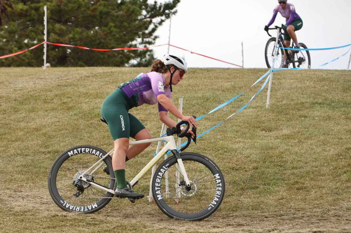 A Peak Pursuits rider cornering on an Orbea bike with Materiaal wheels during a cyclocross race.